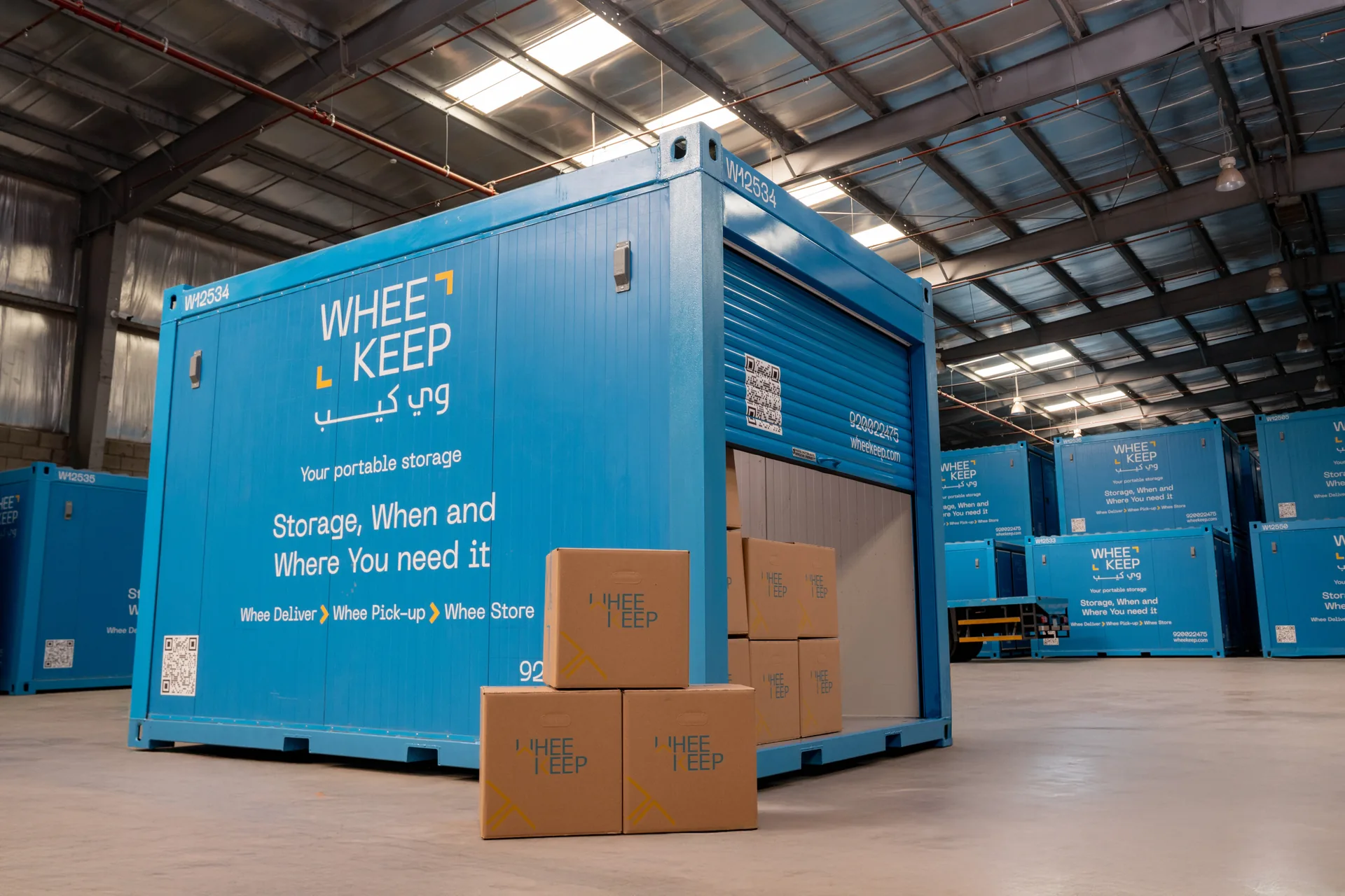 A WheeKeep roll-up-door unit with boxes in front, inside the facility
