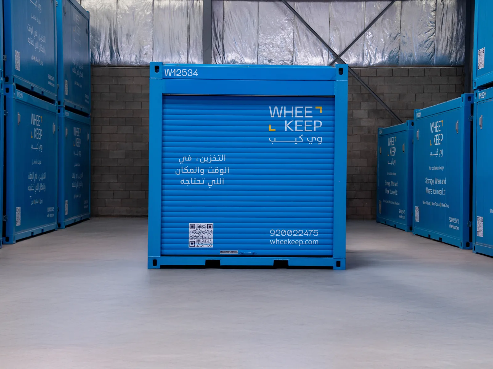 A blue WheeKeep storage unit with a roll-up door inside the facility